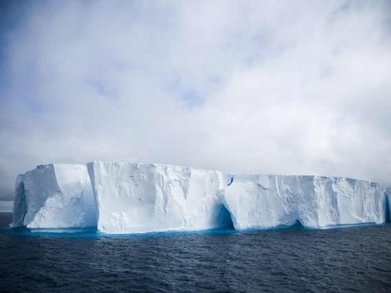 An iceberg again a cloudy sky