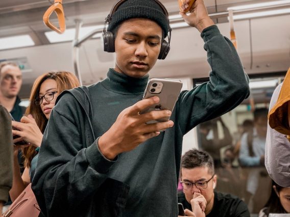 People on their phones, commuting on a crowded train. A perfect example of where a contact tracing app could be useful.