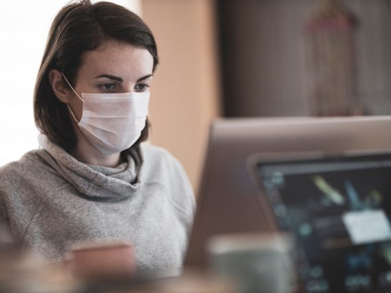 A woman wearing a face covering at work.