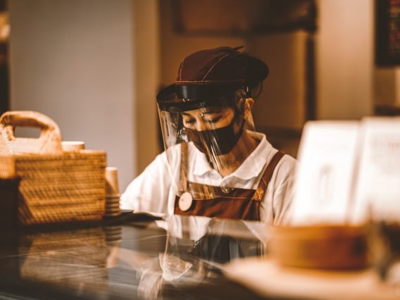 A barista in PPE. Occupations with increased risk of contracting COVID-19 include those in healthcare and other public-facing roles.
